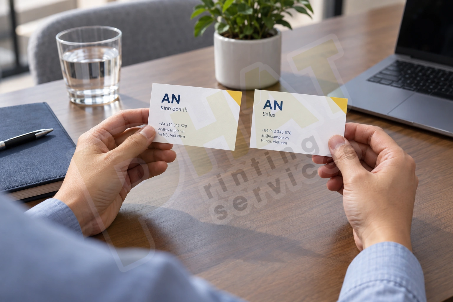 Hai tay cầm danh thiếp AN với nội dung Kinh doanh và Sales trên bàn họp
