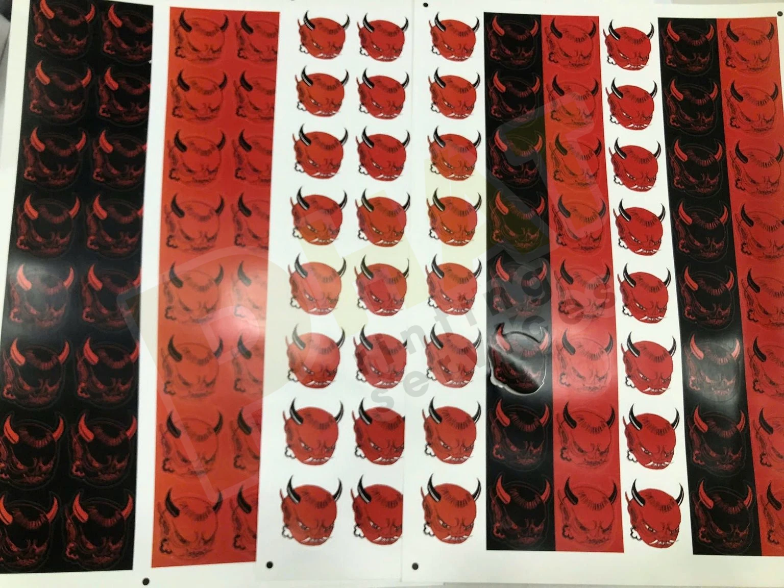 Nhiều dải tem decal in màu đỏ đen bế theo hình, xếp cạnh nhau trên bàn