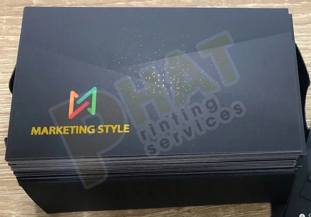 Xấp name card nền đen có logo màu và dòng chữ vàng ánh kim ở góc dưới