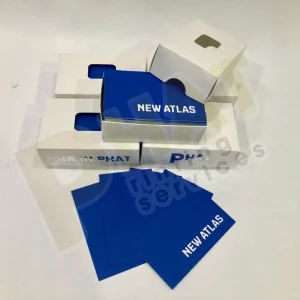 Vài tấm name card nền xanh dương in chữ trắng đặt cạnh hộp đựng