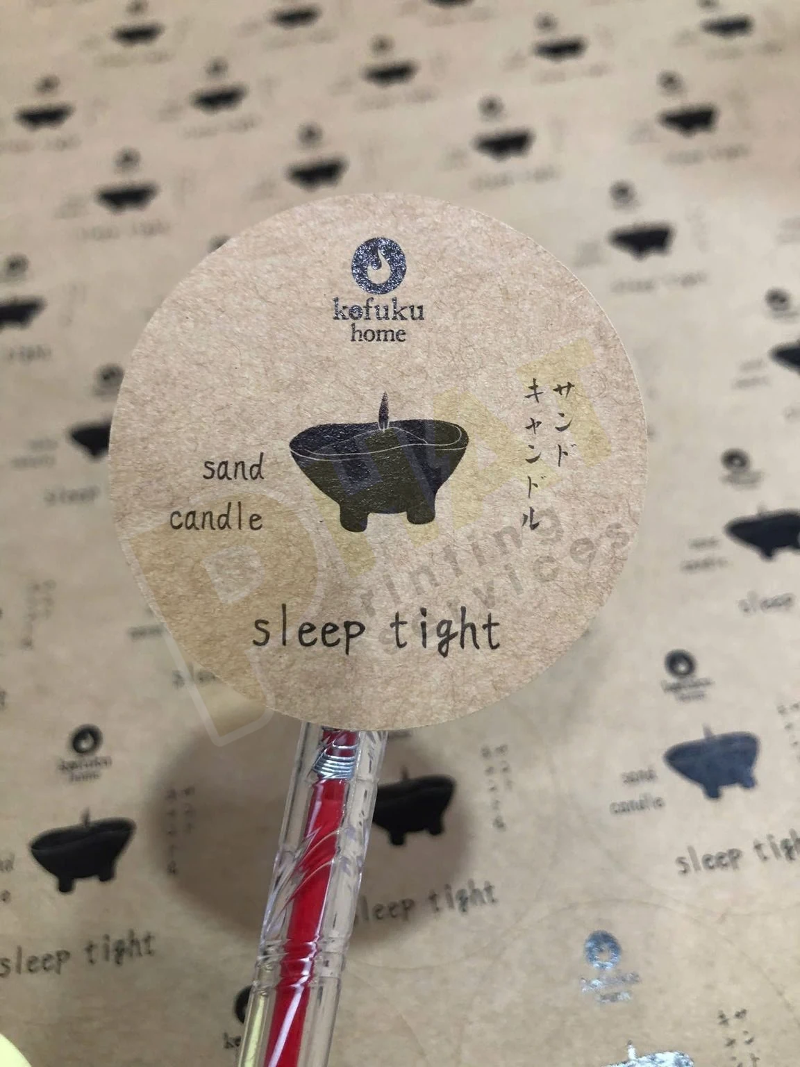 Con tem tròn trên decal giấy kraft in chữ đen, được nhấc lên bằng đầu bút