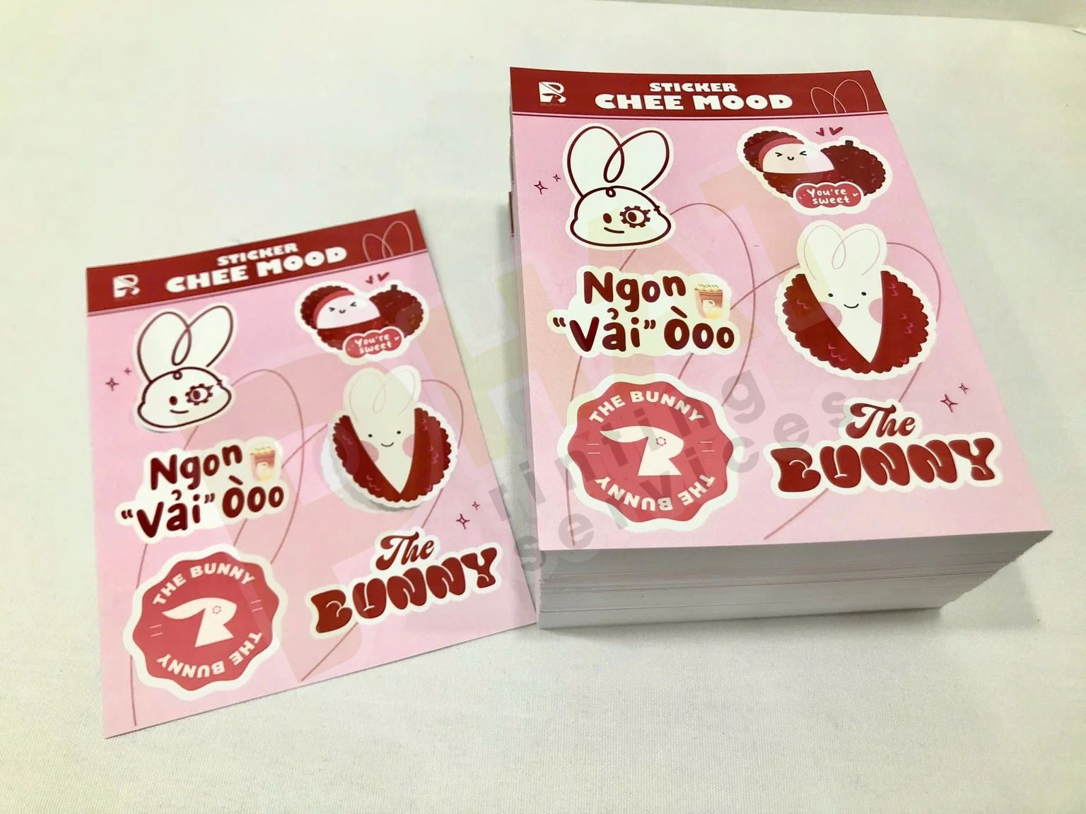 Ấn Phẩm Gói Hàng Shop Online: Bộ Tag, Sticker, Thank You Card 2 Hai tờ sticker nền hồng có nhiều hình bế demi, đặt trên xấp tờ cùng mẫu
