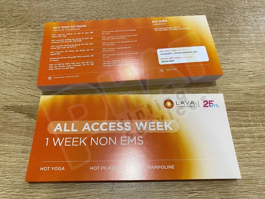 In Voucher Có Số Sê-ri Và Mã QR: Chuẩn Bị Dữ Liệu Và Kiểm Trùng 1 Hai tấm voucher nền cam, một tấm lật thấy mặt sau có quy định sử dụng và ô ghi thông tin